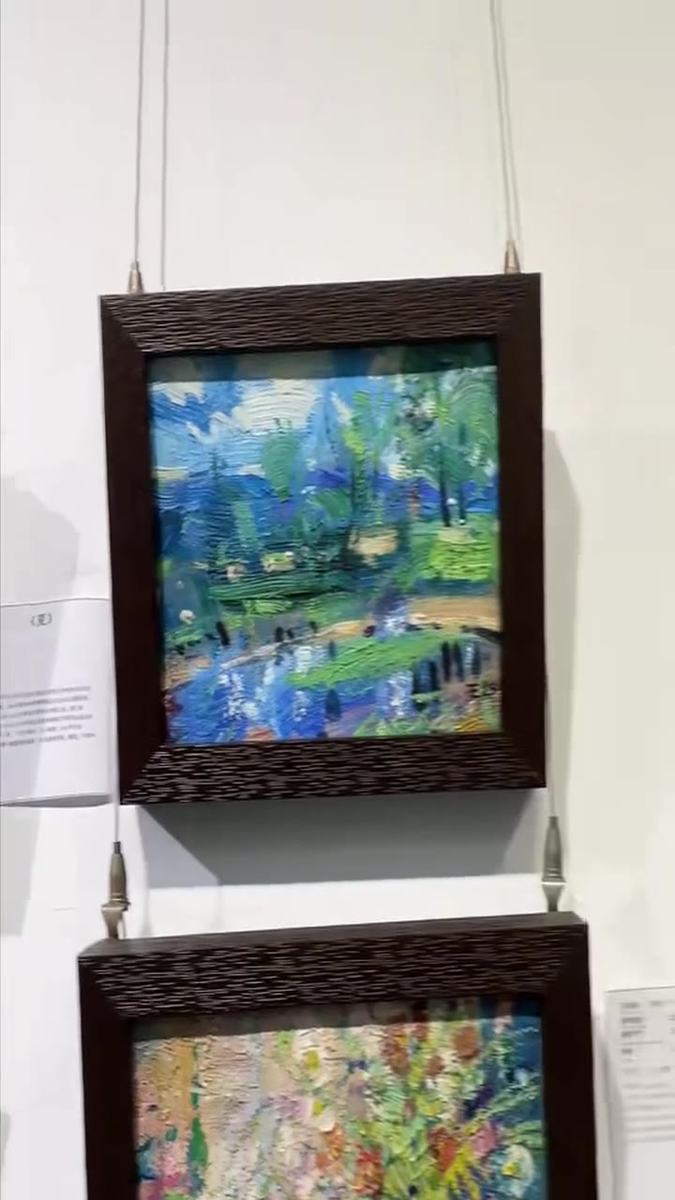 Dafen gallery lane — framed paintings hung on display racks